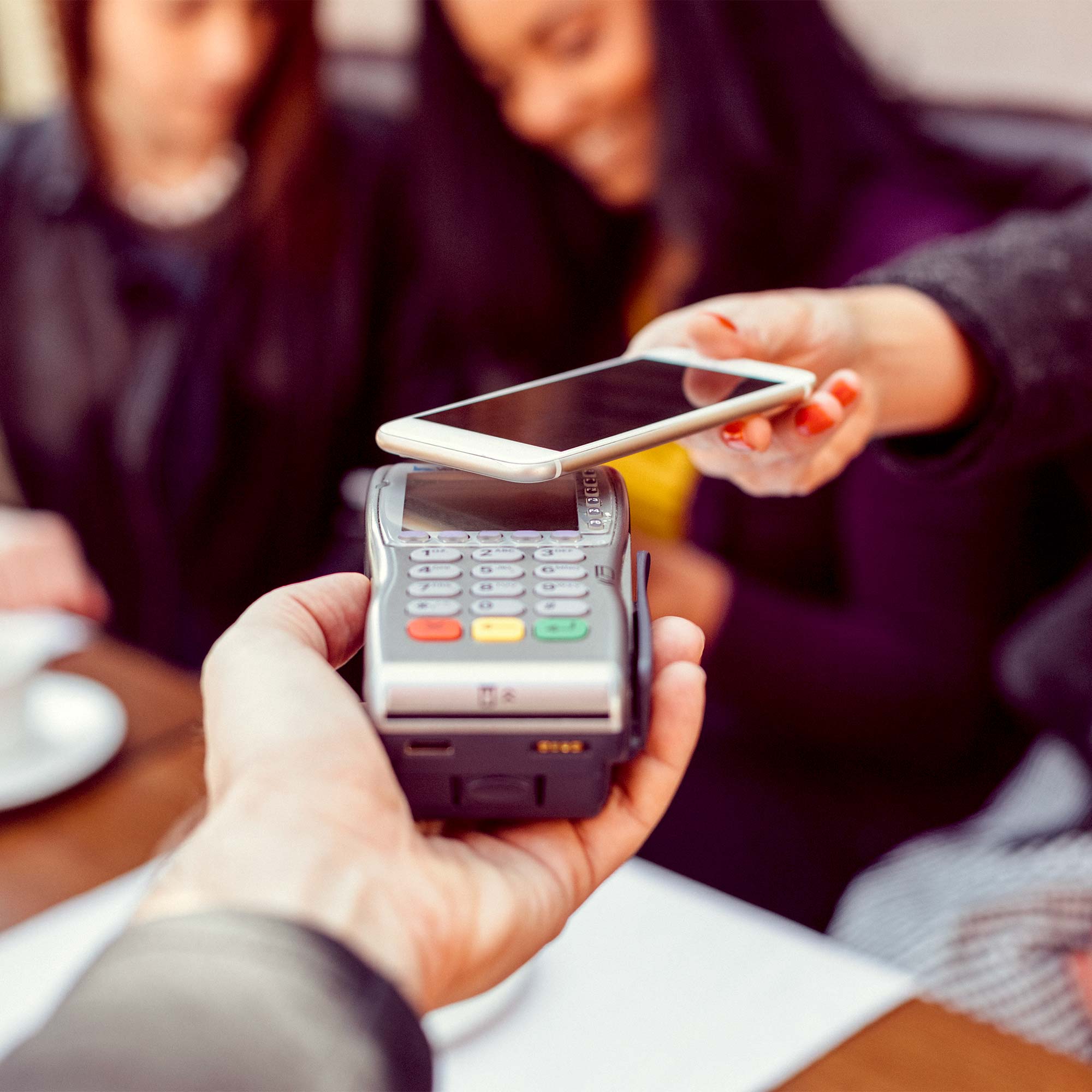 A woman uses her phone to make a digital transaction.